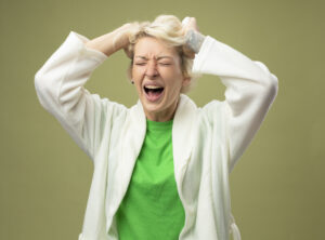 sick-unhealthy-woman-with-short-hair-feeling-unwell-being-frustrated-pulling-her-hair-standing-light-wall